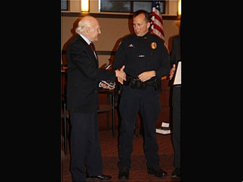 Sen. Herb Kohl presents an award to Onalaska police officer James Page.